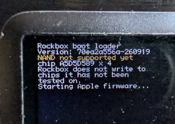 Picture of an iPod nano 3rd generation screen which shows the following white text on a black background: Rockbox boot loader, Version: 70ea2a556a-260919, then a yellow text NAND not supported yet, then a white text which reads chip A5D5D589 x 2, Rockbox does not write to chips it has not been tested on. Starting Apple firmware...